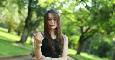 Parmak ve elle davet edilen çekici genç bir kadın. Milenyum kızı, davetkar izleyiciyi davet ediyor