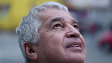 Spiritual middled aged older man looking at sky close-up face with hope