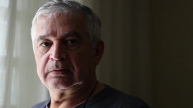 Middle aged man portrait looking at camera. Unshaved senior person