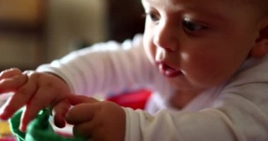 Tatlı bebek çorap giysisini ağzına sokuyor.