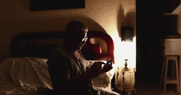 Starší Muž Pomocí Smartphone Před Spaním Noci Posteli — Stock video