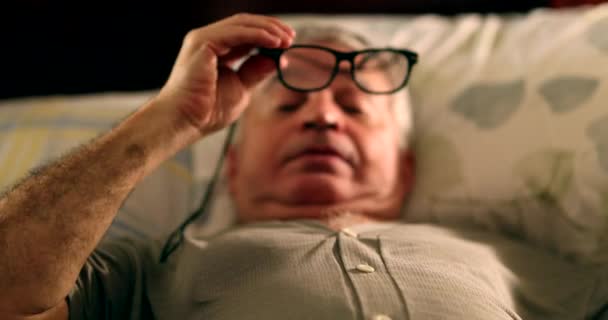 Γέρο Στο Κρεβάτι Βάζοντας Γυαλιά Ανάγνωσης Και Χρησιμοποιώντας Smartphone Νύχτα — Αρχείο Βίντεο