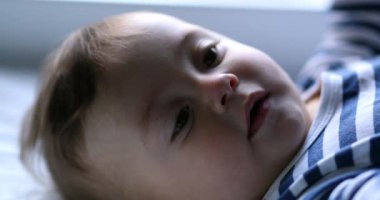 Düşünceli bebek düşüncesi, yeni yürümeye başlayan bebek yakın plan yüzü. Dalgın çocuk kaşlarını çatıyor
