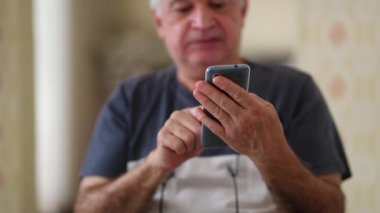 Senior elder man using cellphone device, older person typing on smartphone