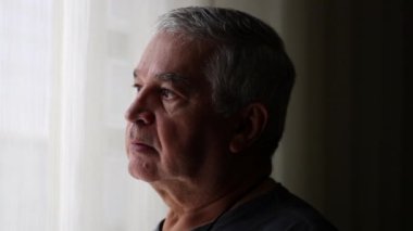 Preoccupied senior man looking outside. Depressed middle aged person