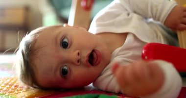 Yerde yatıp kameraya bakan sevimli bir bebek, bebek portresi.