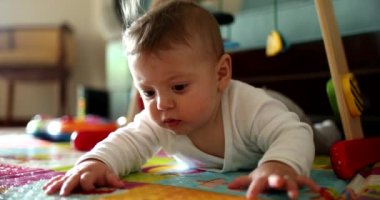 Baby infant lying on play mat learning and discovering the world
