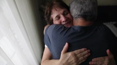 Senior couple embrace indoors. Older wife caring for husband