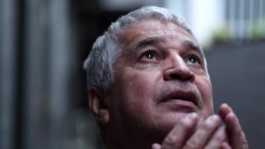 Older man looking at sky with hope and faith