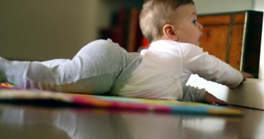 Baby learning to crawl in living-room floor
