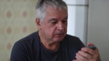 Older man looking at cellphone device. Senior person using smartphone