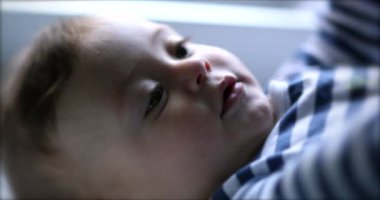 Tatlı düşünceli bebek. Düşünceli güzel bebek yüzü gözlemliyor.