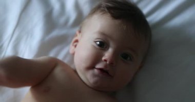 Happy baby infant lying in bed laughing