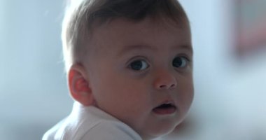 Sevimli bebek yüzlü portre kameraya bakıyor gülümsüyor, bebek gibi gülümsüyor.