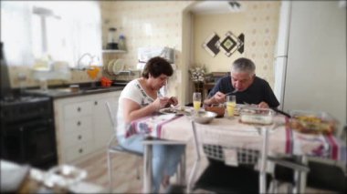 Casual husband and wife eating lunch together at home