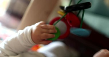 Baby hands touching hanging toy