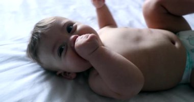 Mutlu bebek bebek bebek, yatakta gülümsüyor.