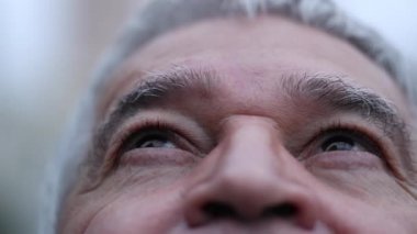 Middle aged man looking at sky, close-up senior eyes closing eyes in contemplation