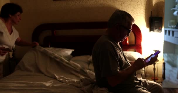 Senior Couple Bed Routine Husband Using Smartphone Sleep — Stockvideo