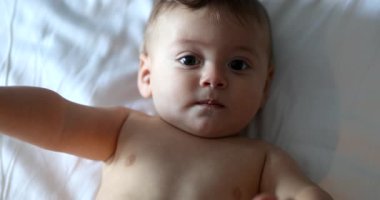 Mutlu bebek bebek bebek, yatakta gülümsüyor.