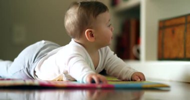 Bebek oturma odasında yerde yatıyor. Sevimli şirin bebek emeklemeyi öğreniyor.