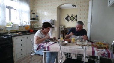 Older couple eating lunch at home. Casual, real people
