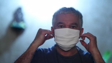 Middle aged man removing face mask end of covid-19