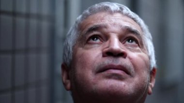 Senior person close-up face eyes to sky having faith