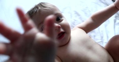 Cute baby grabbing camera lens, infant toddler hitting lens. child hand touching camera