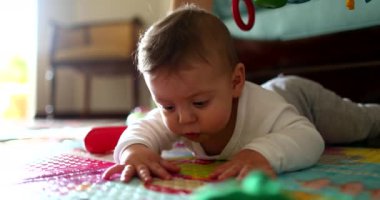 Beautiful baby toddler lying on play mat