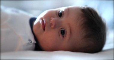 Tatlı bebek bebek yatakta uzanıyor. Tatlı bebek yüzü, yakın plan.