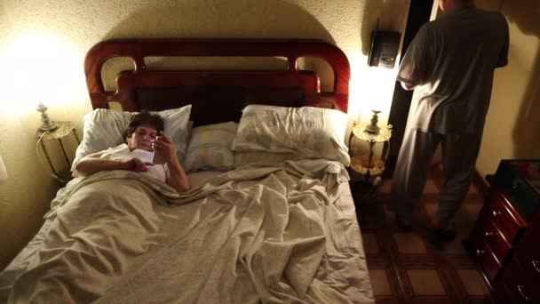 Older Couple Bed Night Ritual Husband Entering Room Lying Bed — Vídeos de Stock