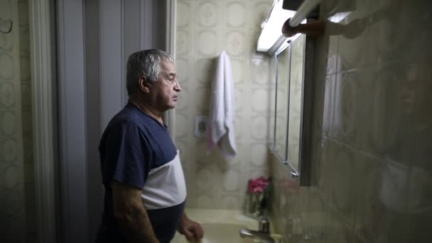 Senior Man Staring Bathroom Mirror Person Turning Fluorescent Light — Vídeos de Stock