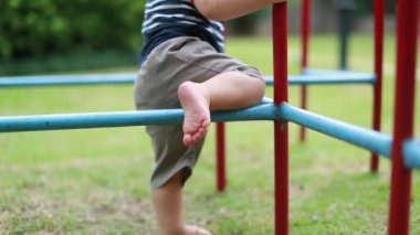 Infant baby playing at playground monkey bar