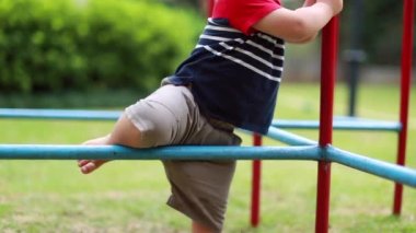 Toddler infant attempting struggling to climb monkey metal bar