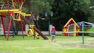 Baby toddler playing at playground outdoors. Infant running on grass outside