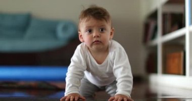 Sevimli bebek bebek dört dizle kameraya gülümsüyor.