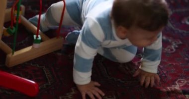 Oyun odasında oyuncaklarla oynayan sevimli bir bebek. Bebek kutudan oyuncak çıkarıyor.