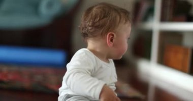 Evin içinde, ahşap zeminde sürünen şirin bir bebek. Çocuk gelişimi