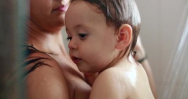 Mother showering with baby. Mom bathing in shower with toddler infant
