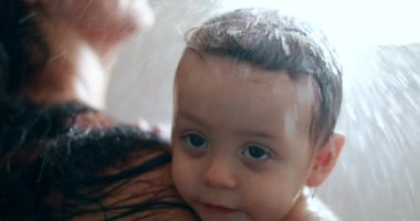Mother showering with baby. Mom bathing in shower with toddler infant