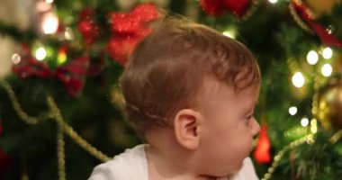 Noel tatilinde erkek bebek portresi. Arkaplanda yanıp sönen ışık olan bebek