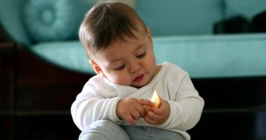 Neşeli bebek elinde meyve gözlemi tutan bir bebek.