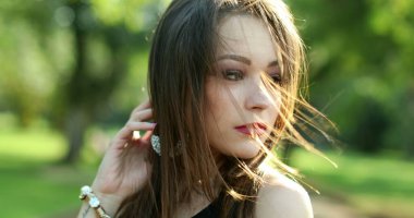 Mutlu, İspanyol asıllı, genç, yirmili yaşlarda, açık hava parkında gülümseyen bir kadın.