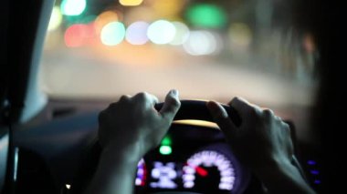 Driver POV holding steering wheel driving at night perspective