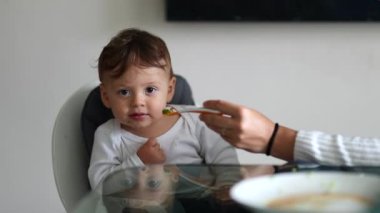 Baby toddler refusing feeding, infant one year sitting on highchair denying food