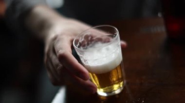 Man picks up beer glass drinking