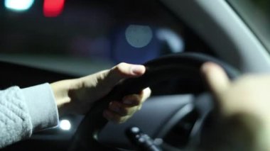 Hands holding steering wheel driving at night in slow-motion 120fps