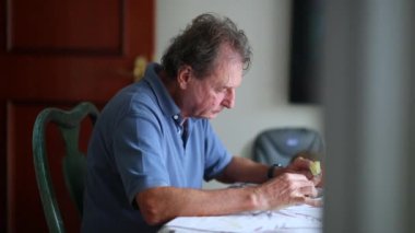 Candid senior man eating lunch. Casual older person eating meal