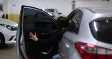 Kadın sürücü park ettikten sonra arabadan iniyor. Arabanın kapısını açan ve kapatan kişi